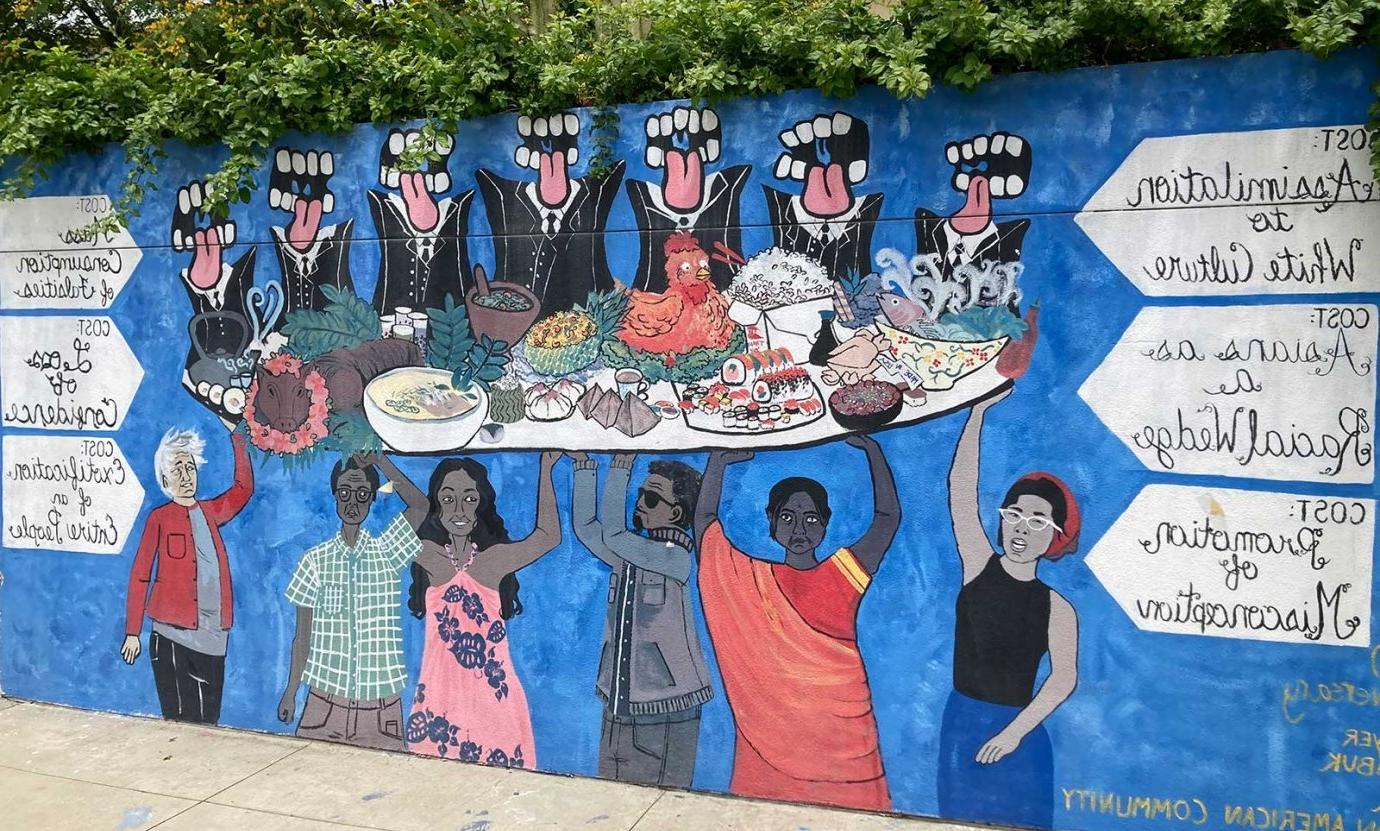 a view of the capas mural showing several people holding up a platter of food